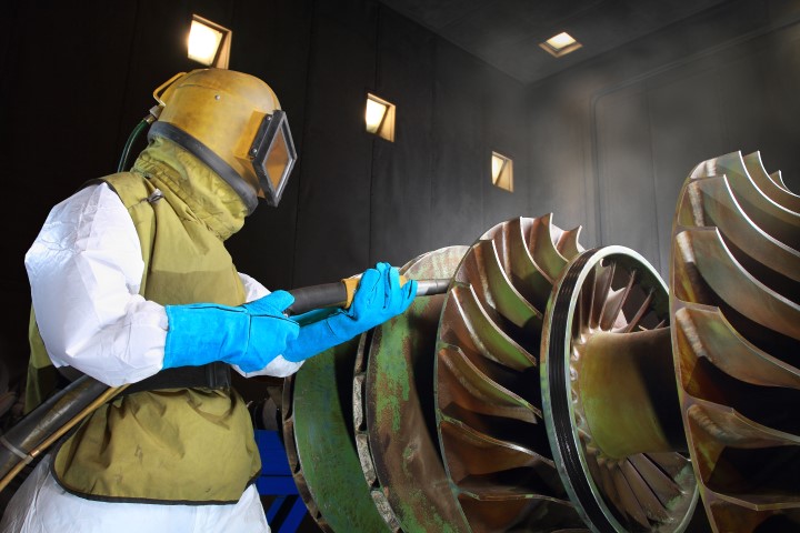 Muž v nezpečnostním obleku tryská turbíny