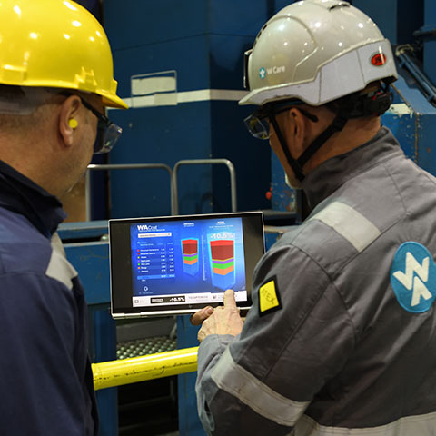 Dva technici se dívají na graf na tabletu